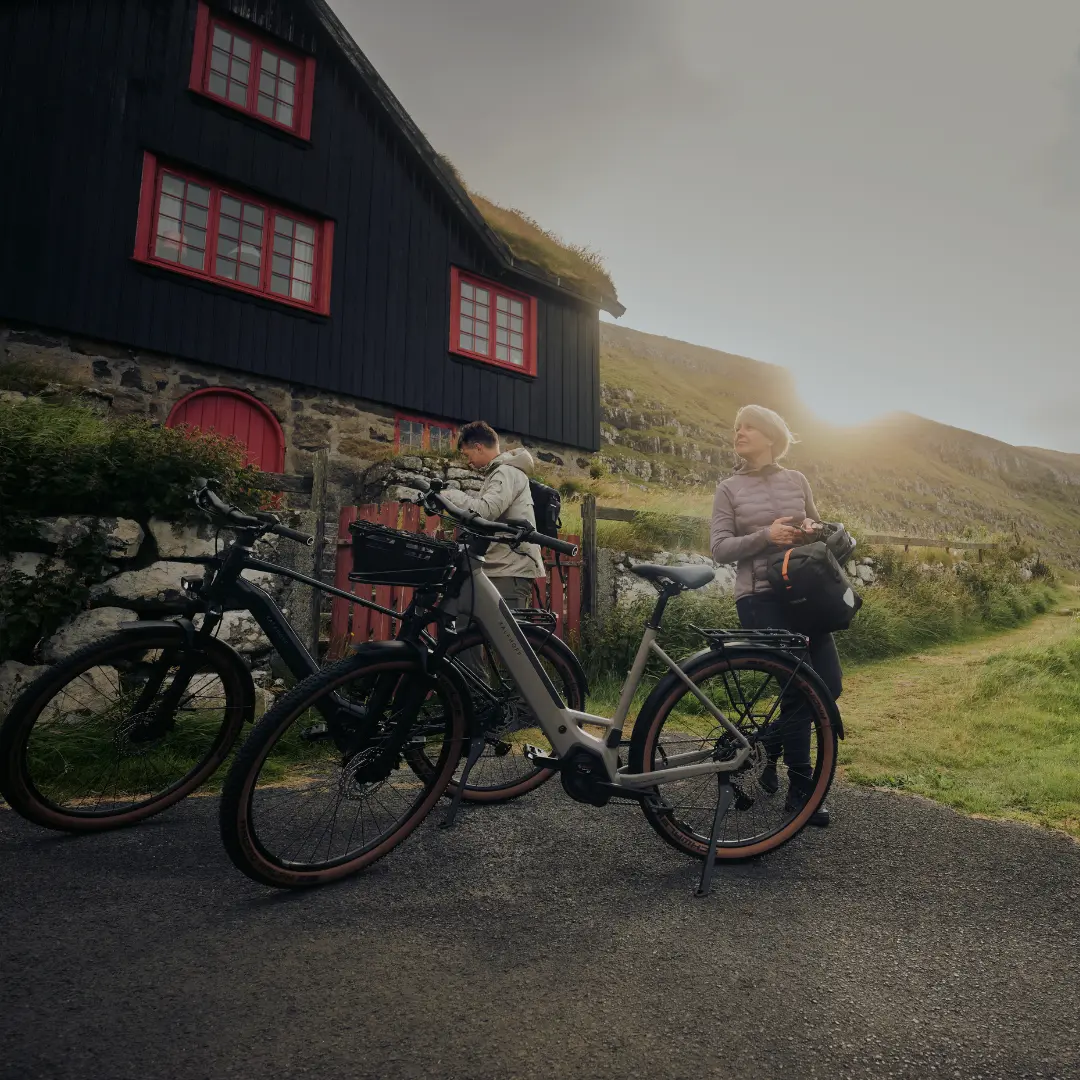 Zwei Trekking E-Bike Fahrer die gerade pausieren und neben den Fahrrädern stehen